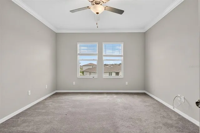 an empty room with a window and a ceiling fan