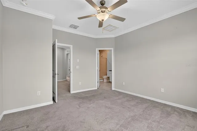 a view of an empty room and chandelier fan