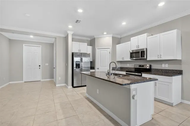 a kitchen with stainless steel appliances granite countertop a refrigerator and a stove top oven