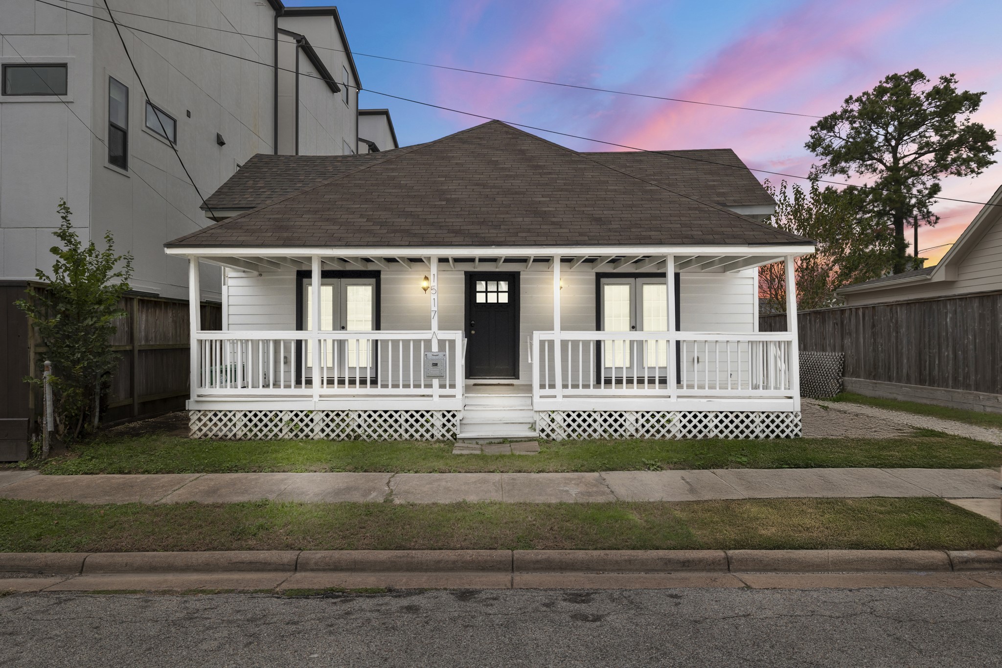 Charming single-story home with a welcoming front porch and classic white exterior. The house features a gabled roof and ample windows for natural light.