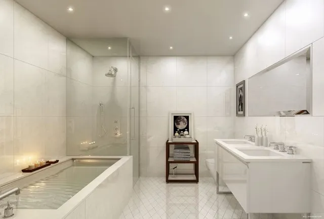 a bathroom with a tub a double vanity sink and a mirror