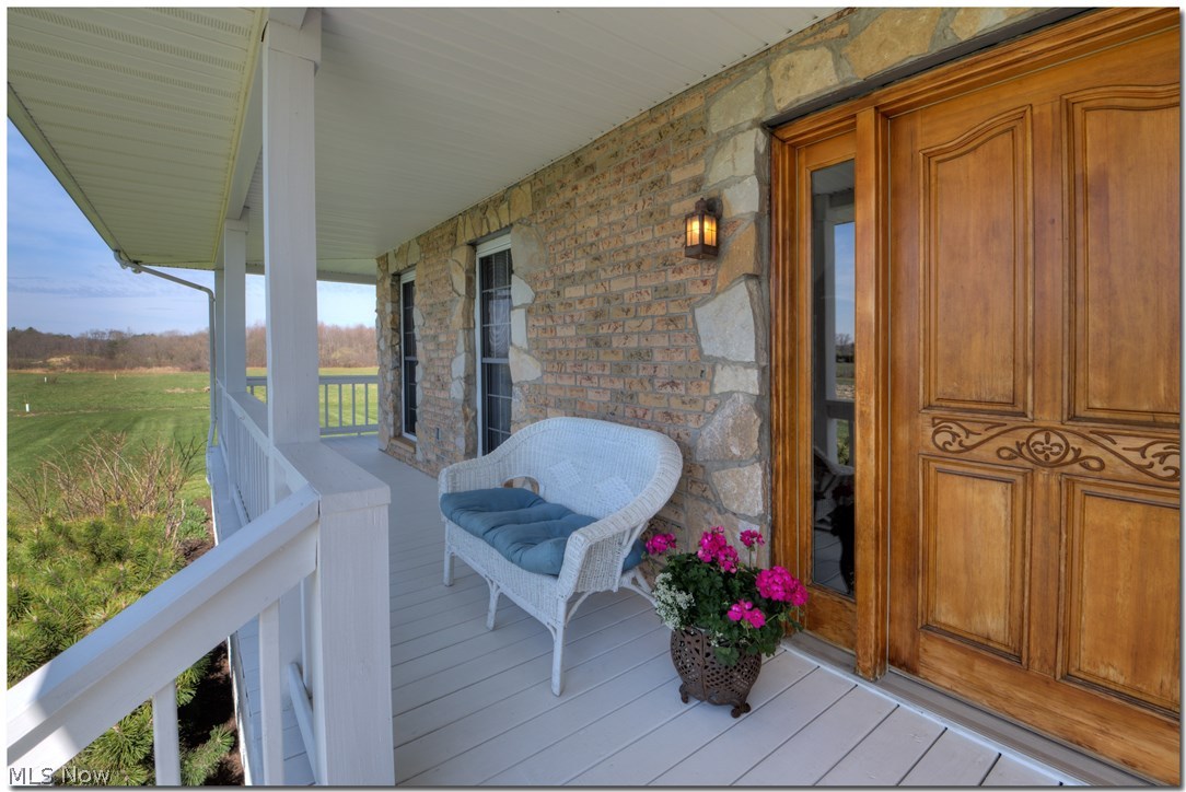 17580 Huntley Road Windsor, OH 44099 - Photo 3 of 35 Every day can be enjoyed outside with an overhang on 3 sides-- and a 3 season room on rear of home. Custom stone surround frames the floor to ceiling windows.