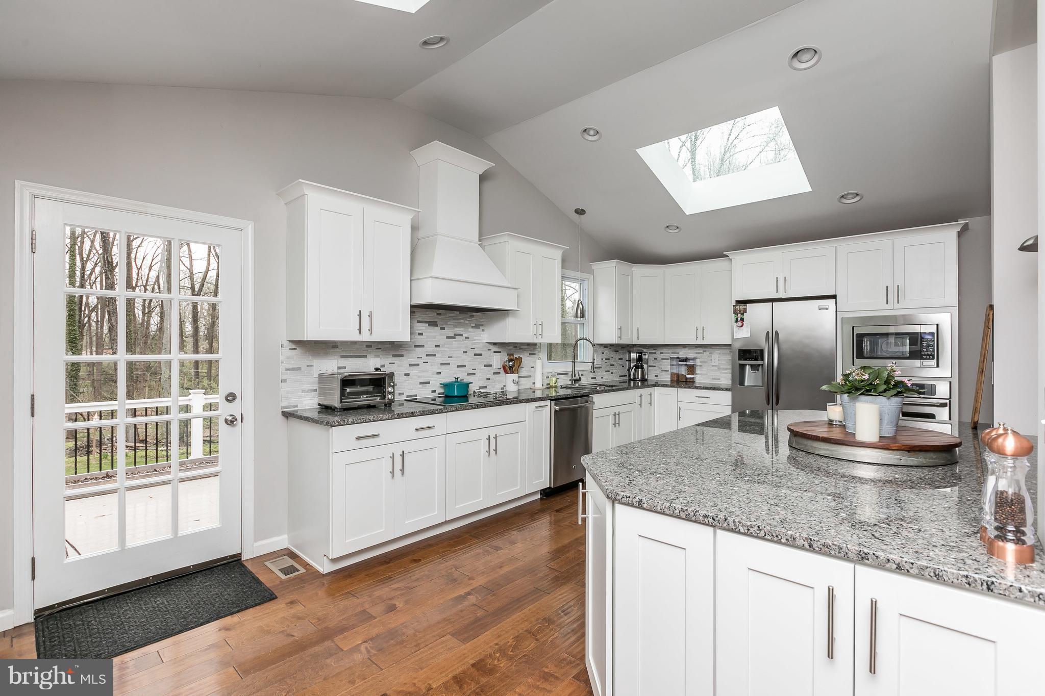 1310 Milldam Road Baltimore, MD 21286 - Photo 5 of 29 a kitchen with granite countertop white cabinets and stainless steel appliances