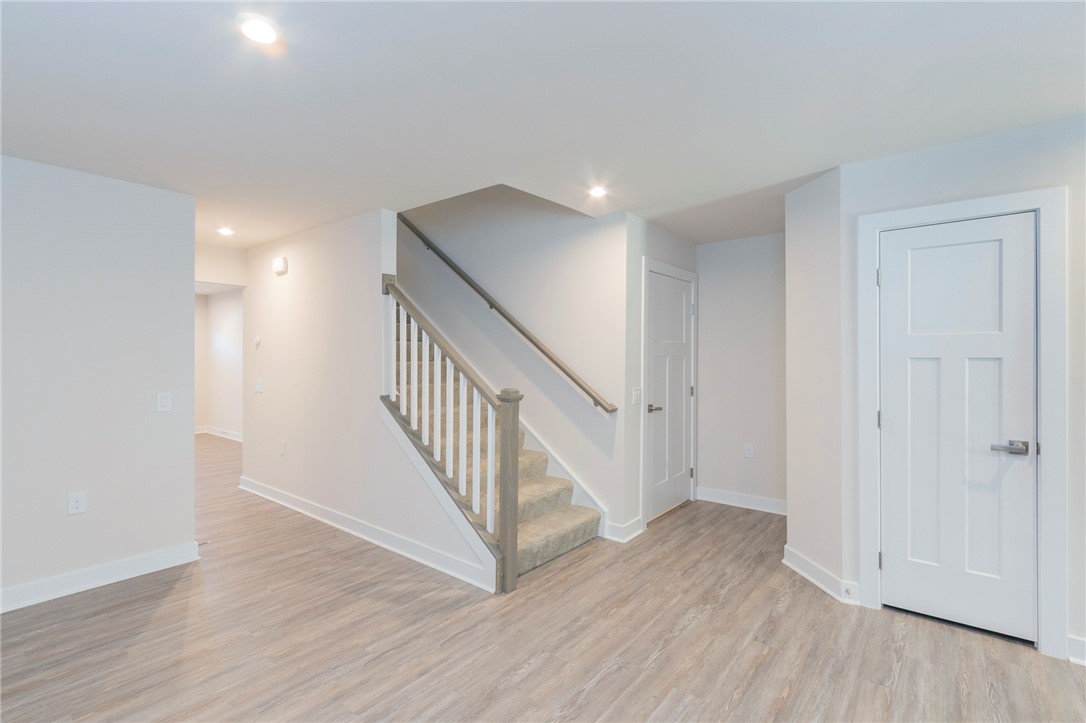 233 Scenic Road Anderson, SC 29621 - Photo 9 of 50 Clean lines define this bright interior space, featuring wood-look flooring and a carpeted staircase leading to upper levels.