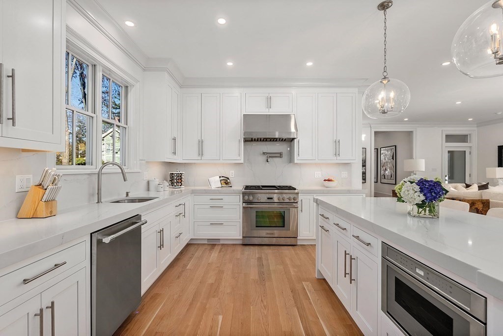 15 Sterling Street Newton, MA 02465 - Photo 13 of 39 a kitchen with stainless steel appliances granite countertop a sink dishwasher a stove a refrigerator and a dining table with wooden floor