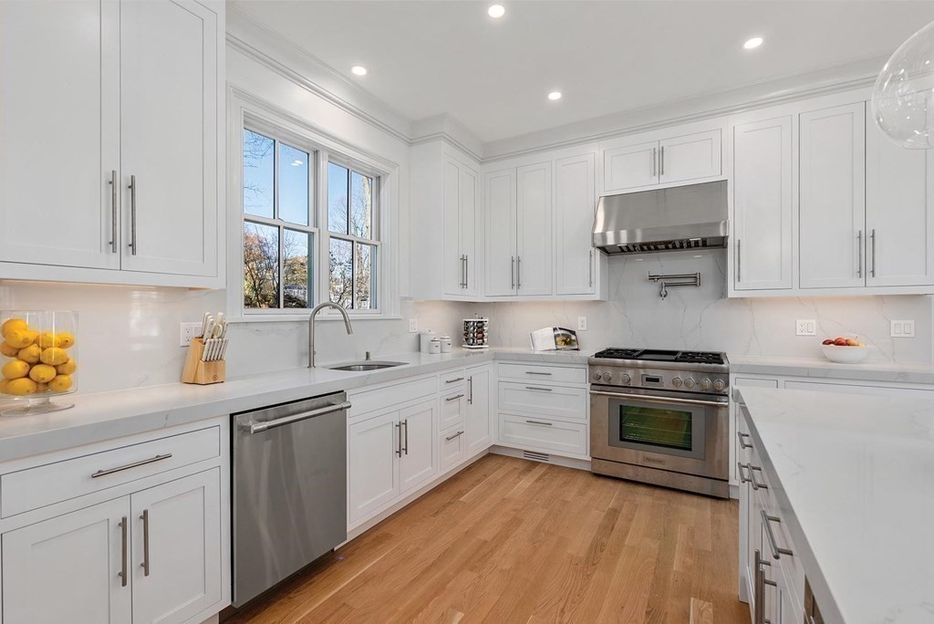 15 Sterling Street Newton, MA 02465 - Photo 14 of 39 a kitchen with stainless steel appliances granite countertop a sink a stove and cabinets