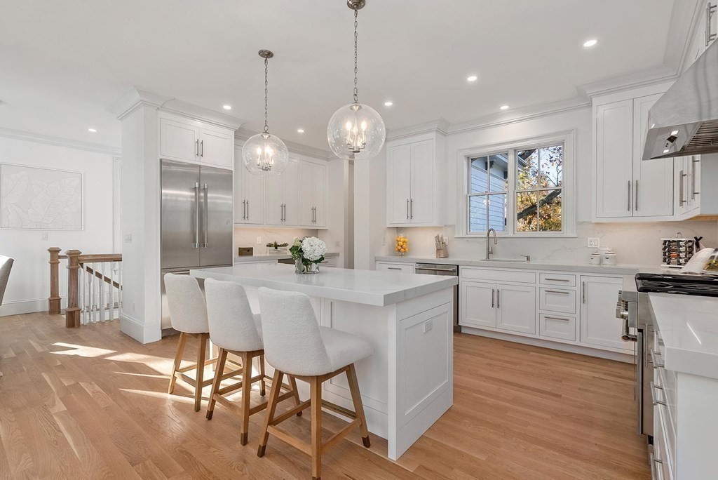 15 Sterling Street Newton, MA 02465 - Photo 16 of 39 a kitchen with stainless steel appliances kitchen island granite countertop a stove a refrigerator a oven a dining table and chairs with wooden floor