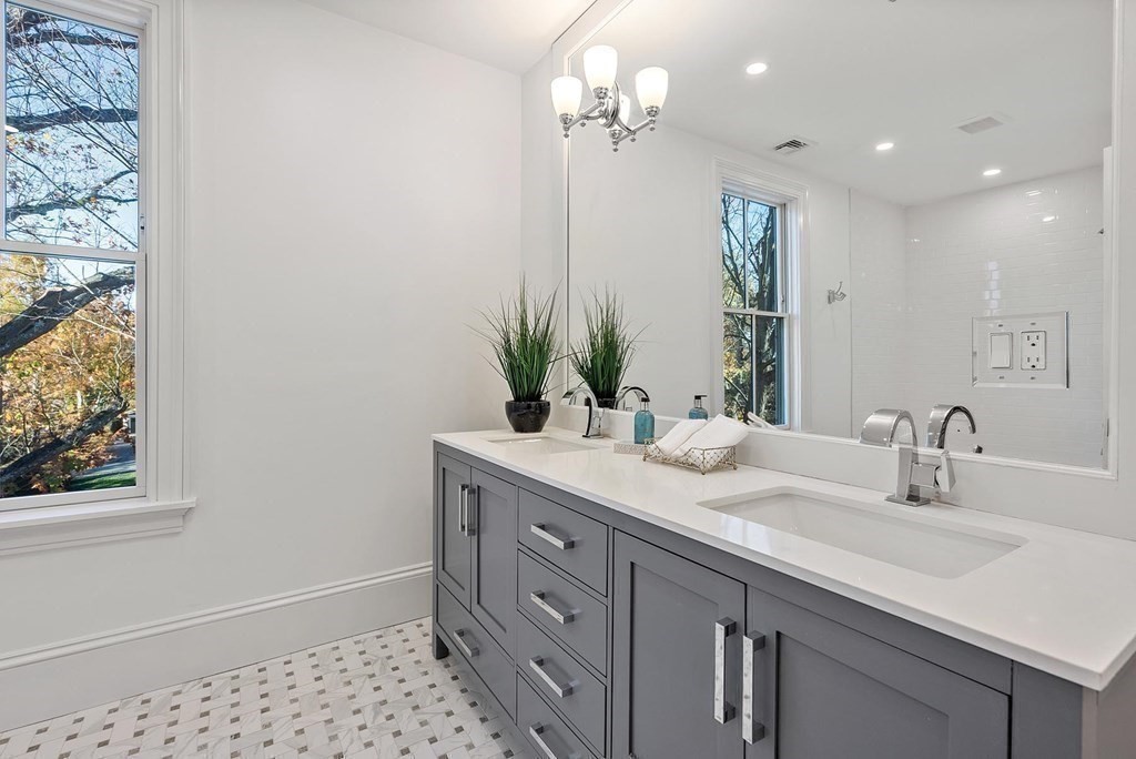 15 Sterling Street Newton, MA 02465 - Photo 25 of 39 a bathroom with a sink a large mirror and a shower