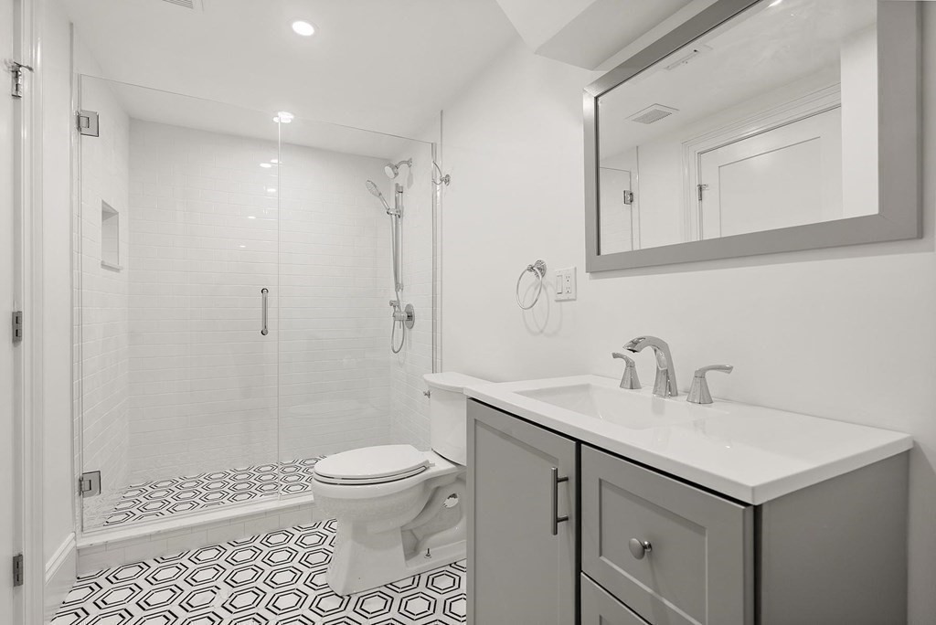 15 Sterling Street Newton, MA 02465 - Photo 32 of 39 a bathroom with a sink toilet a mirror and shower