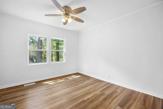 an empty room with a window and a fan