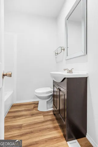 a bathroom with a sink toilet and mirror