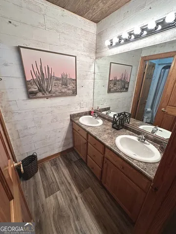 a bathroom with a sink a mirror and a painting on the wall