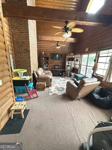 a living room with furniture a flat screen tv and a large window