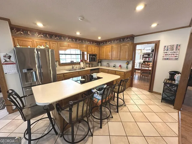 a kitchen with stainless steel appliances a table chairs and a refrigerator
