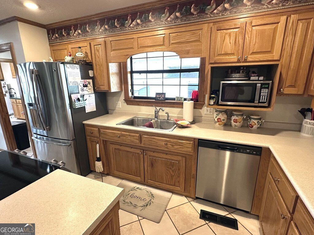 4448 Old Lake Park Road Valdosta, GA 31606 - Photo 5 of 40 a kitchen with stainless steel appliances a stove refrigerator sink and microwave