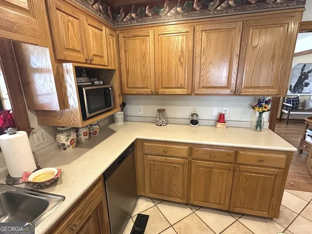 a kitchen with stainless steel appliances a sink a stove a microwave cabinets and a counter top space