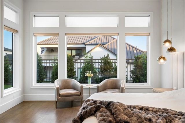 a bedroom with a bed and large windows