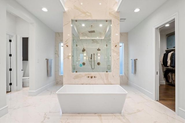 a spacious bathroom with a tub shower and mirror