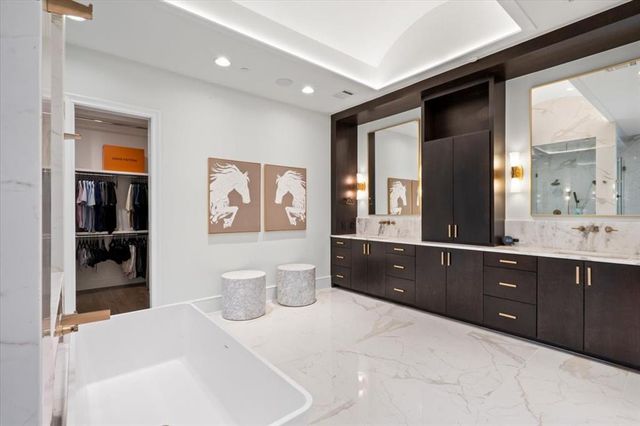 a spacious bathroom with a bathtub sink and mirror