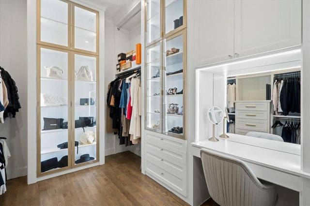 a view of walk in closet with clothes and shoes