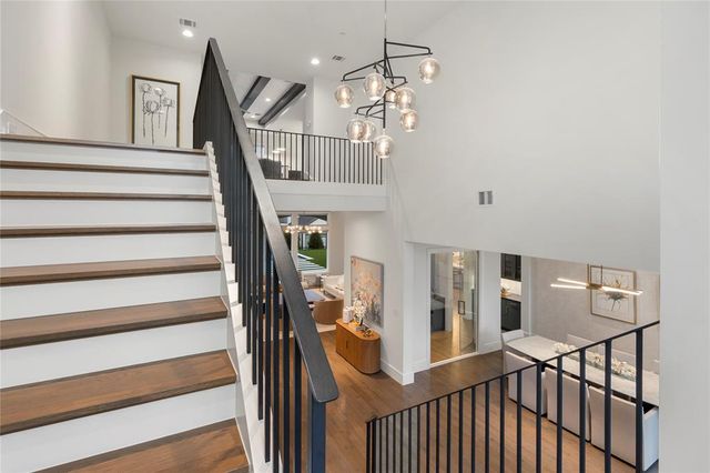 a view of staircase with railing and white walls