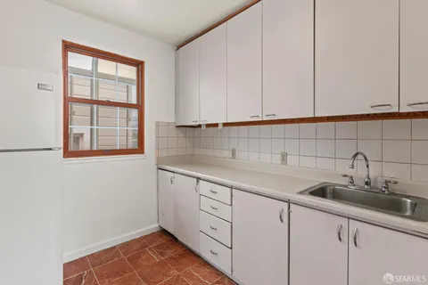 a kitchen with white cabinets and a sink