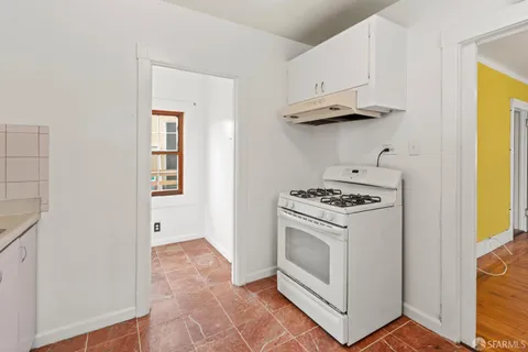 a kitchen with white cabinets and a stove