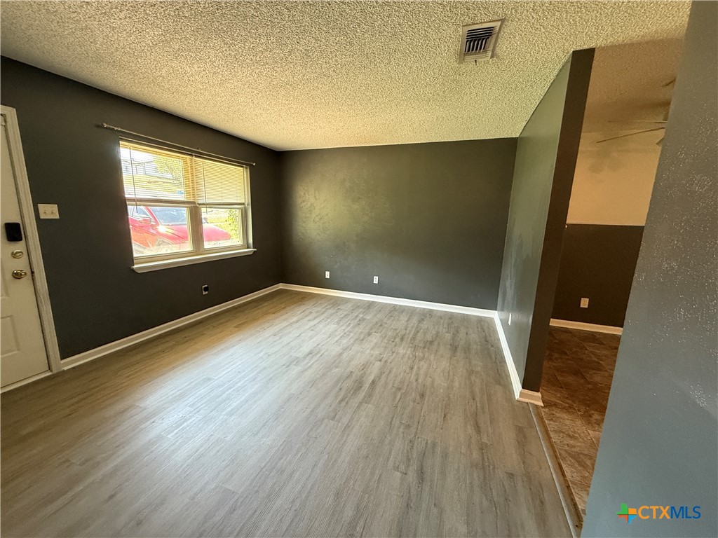 809 Michelle Drive Copperas Cove, TX 76522 - Photo 3 of 12 an empty room with wooden floor and windows