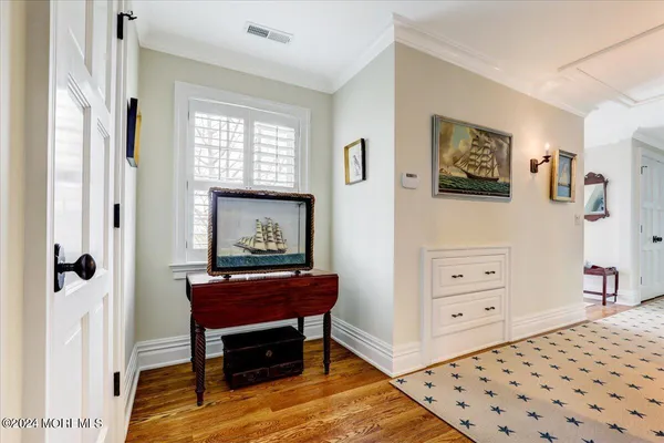 a view of a balcony with wooden chairs and floor to ceiling window