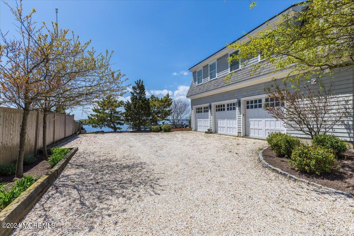 225 Channel Lane Mantoloking, NJ 08738 - Photo 5 of 85 a front view of a house with a yard and a garden
