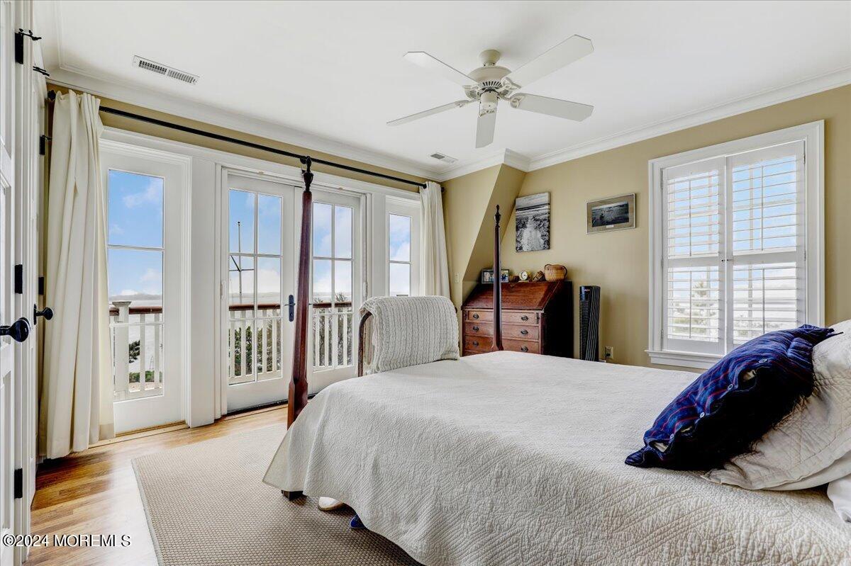 225 Channel Lane Mantoloking, NJ 08738 - Photo 53 of 85 a bedroom with a large bed and a chandelier