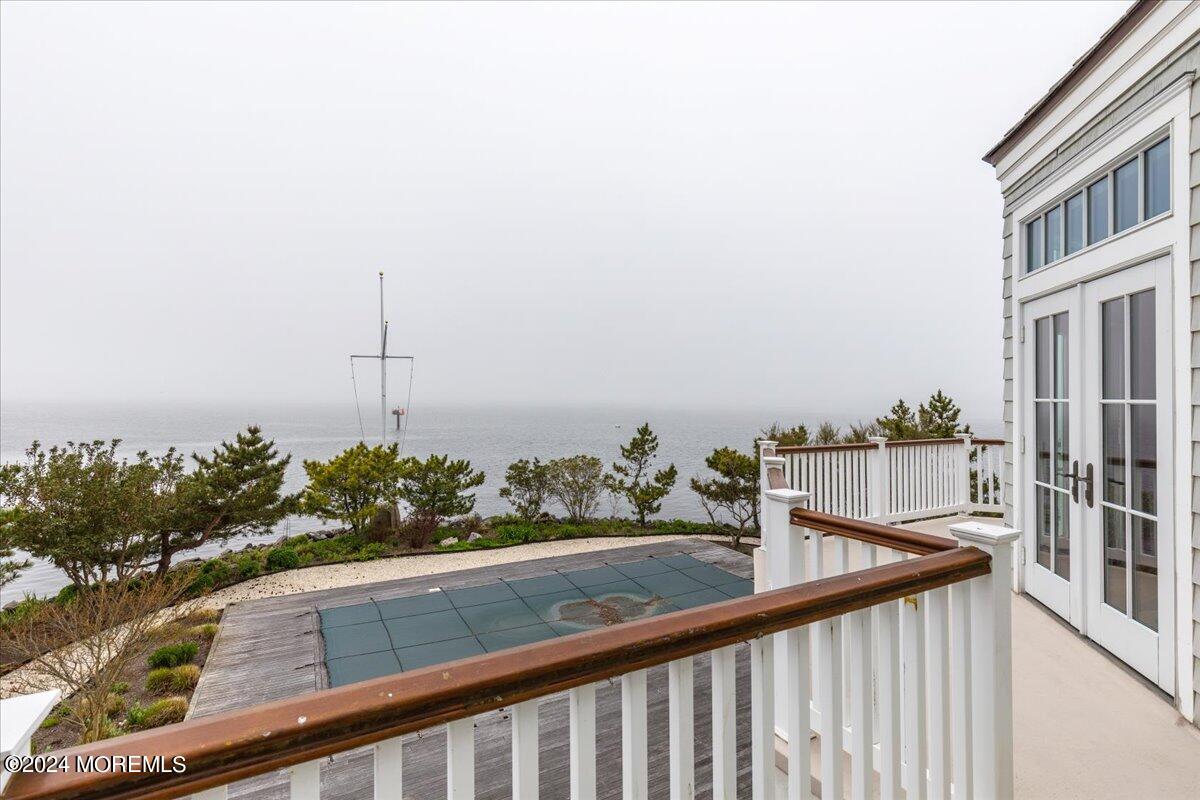 225 Channel Lane Mantoloking, NJ 08738 - Photo 79 of 85 a view of a balcony with wooden chairs and floor to ceiling window