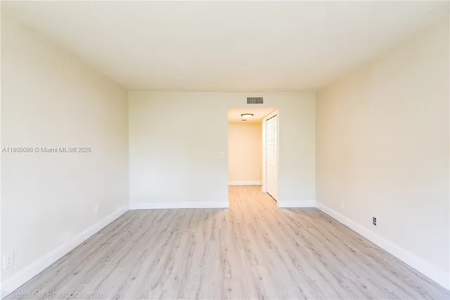 a view of an empty room and wooden floor