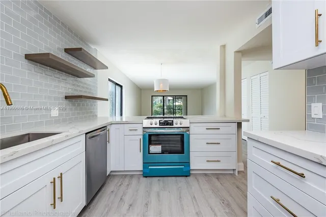 a kitchen with cabinets stainless steel appliances and a counter space