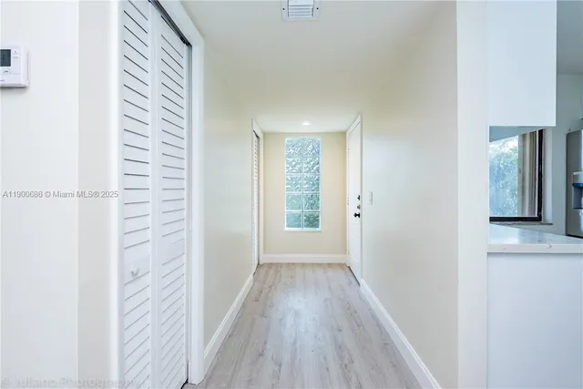 a view of hallway with a large window and wooden floor