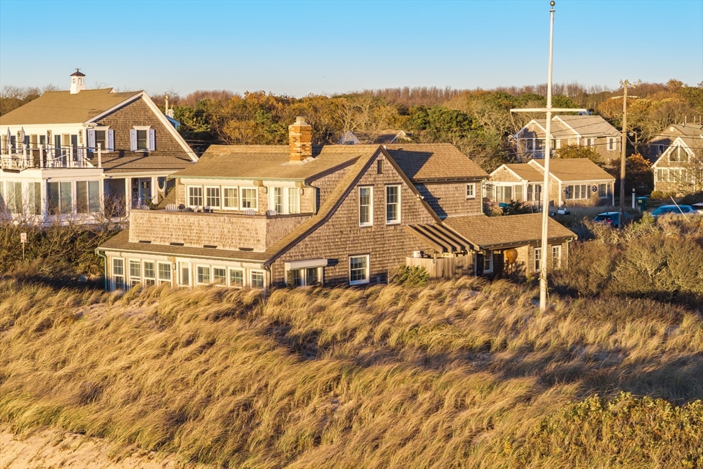 1145 Kingsbury Beach Road Eastham, MA 02642 - Photo 6 of 42 a view of a white house with a ocean view