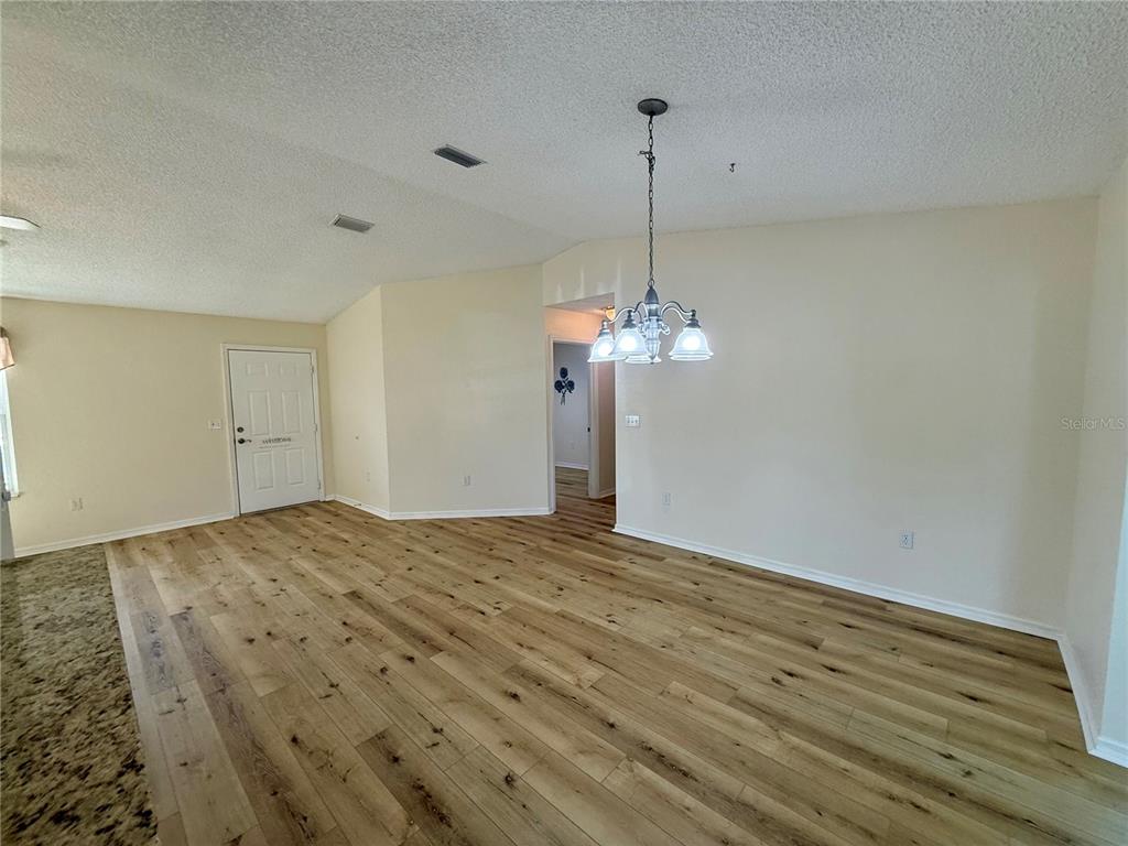 8287 Southwest 116th Street Ocala, FL 34481 - Photo 15 of 40 a view of empty room with wooden floor and chandelier