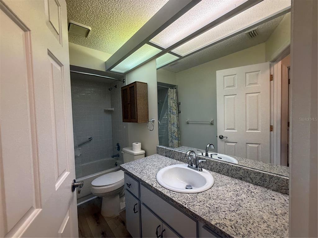 8287 Southwest 116th Street Ocala, FL 34481 - Photo 25 of 40 a bathroom with a granite countertop sink a mirror and a toilet