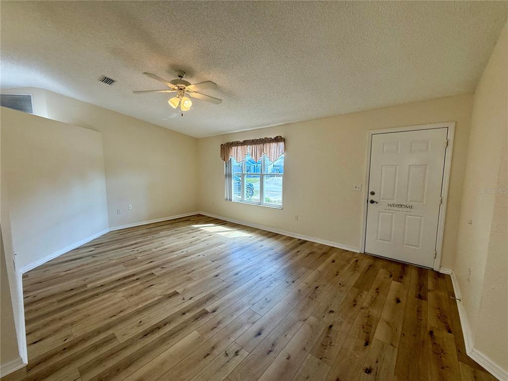 8287 Southwest 116th Street Ocala, FL 34481 - Photo 5 of 40 wooden floor in an empty room with a window