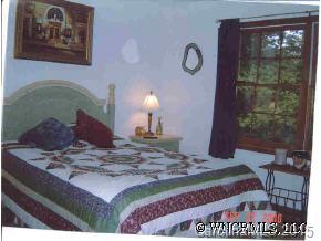 375 Riddle Cove Road Maggie Valley, NC 28751 - Photo 2 of 10 a bed sitting in a bedroom with a balcony