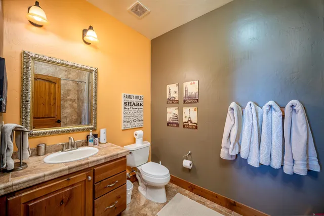 a bathroom with a granite countertop sink toilet and a mirror