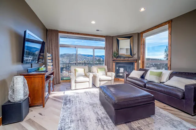 a living room with furniture large windows and a flat screen tv