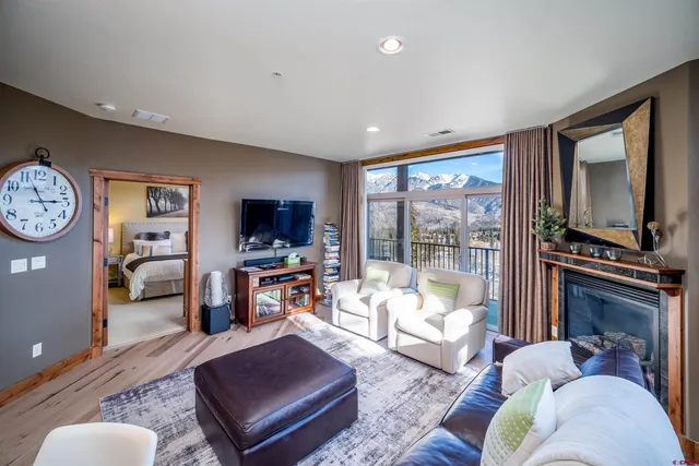 a living room with furniture a flat screen tv and a fireplace