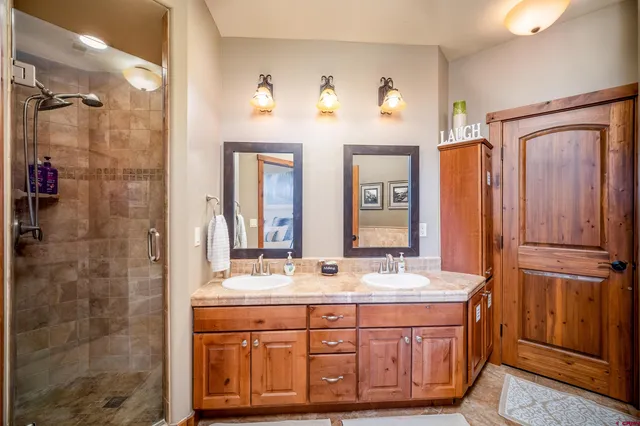 a bathroom with a granite countertop sink a mirror and a shower