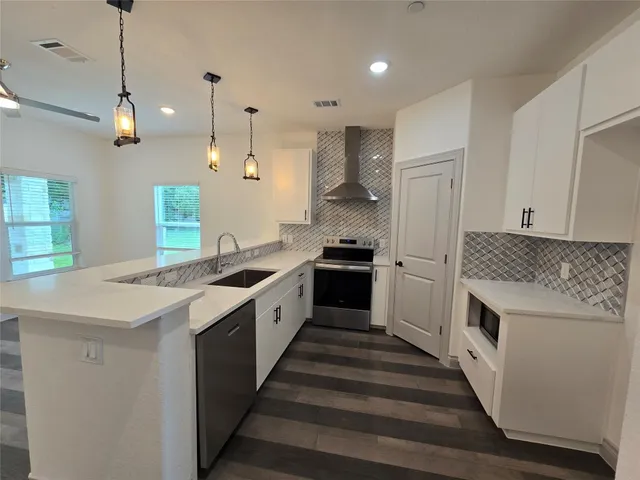 a kitchen with stainless steel appliances a stove a sink and a refrigerator