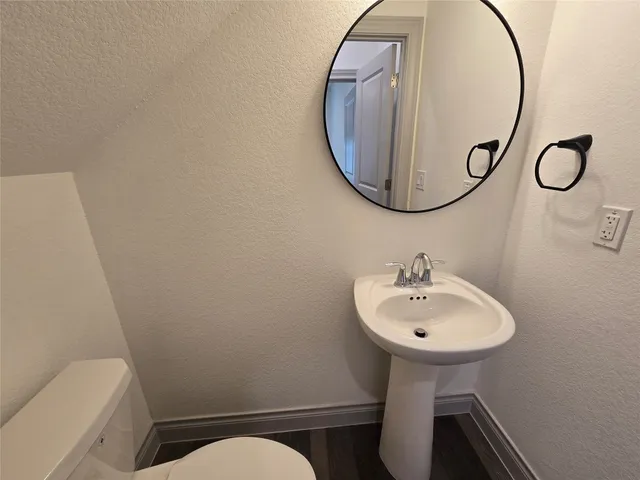 a bathroom with a sink mirror and toilet