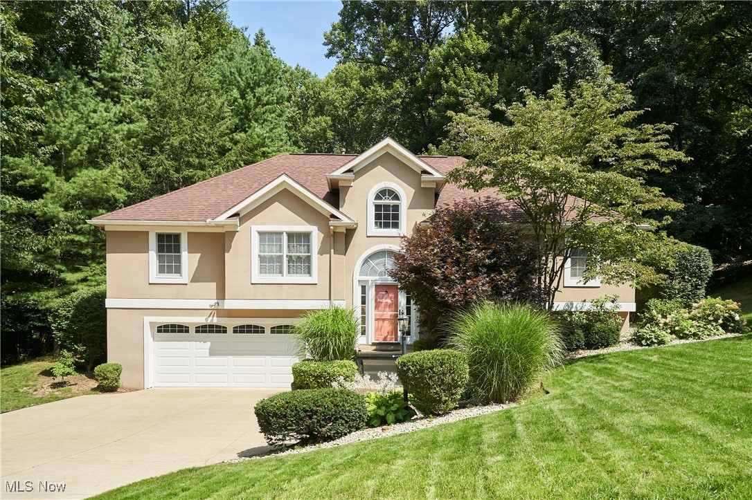 4535 Pinewood Path Akron, OH 44321 - Photo 1 of 27 View of front of house with stucco siding, a garage, concrete driveway, a front lawn, and a shingled roof