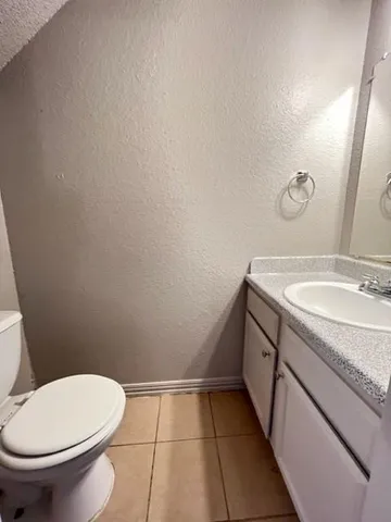 a bathroom with a granite countertop toilet and sink