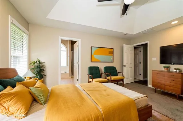 a bedroom with a bed and a flat tv screen on dresser