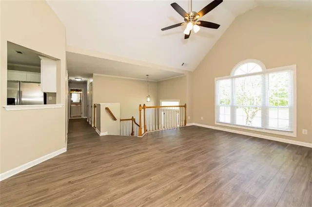 a view of an empty room with wooden floor and a window
